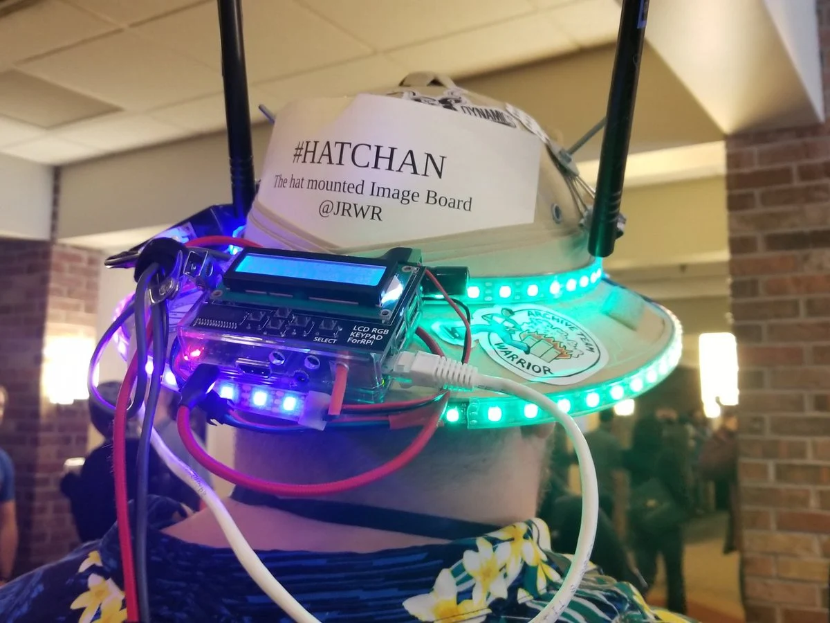 HatChan’s pith helmet fitted with antennas, an LCD, and glowing LED strips.